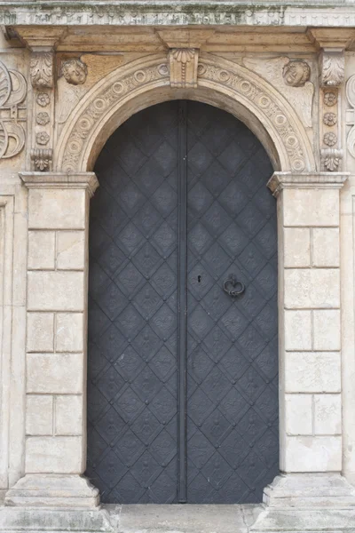 Antigua puerta texturizada iglesia con fachada de arco de piedra. Cracovia — Foto de Stock