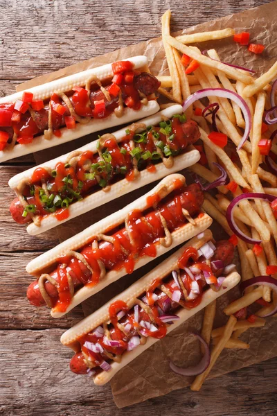 hot dogs with ketchup, mustard, onions and french fries. vertica