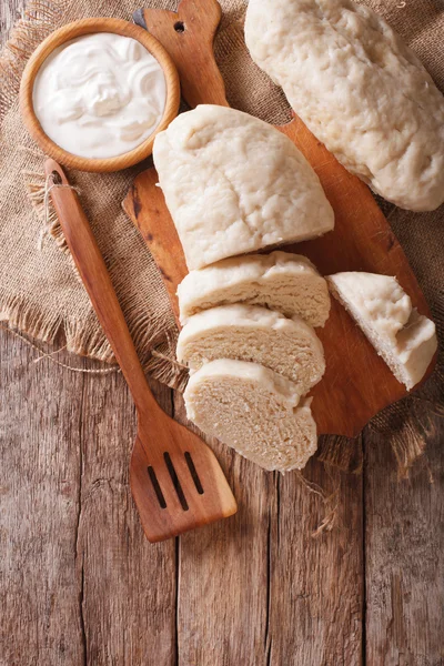 Czech cuisine: sliced boiled knedliks close-up on chopping board — Stock Photo, Image