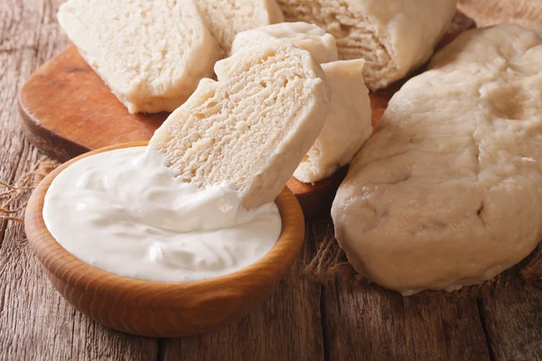 Boiled knedliks with sour cream macro on the table. Horizontal — Stock Photo, Image