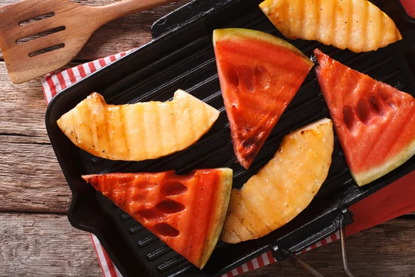 Scheiben von reifen Wassermelonen und Melonen in einer Pfanne grillen Nahaufnahme. hori — Stockfoto