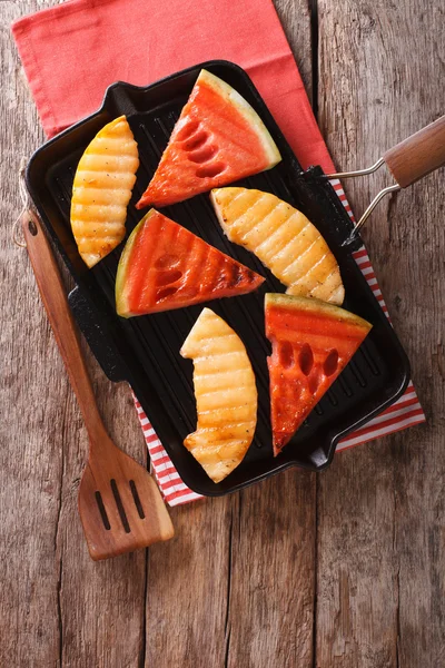 Slices of ripe watermelon and melon in a pan grill closeup. vert — Stock Photo, Image