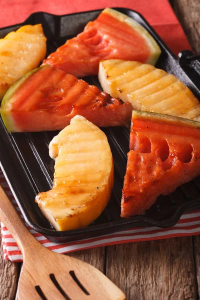 Anguria tagliata a fette e melone in una padella grill primo piano. Verticale — Foto Stock