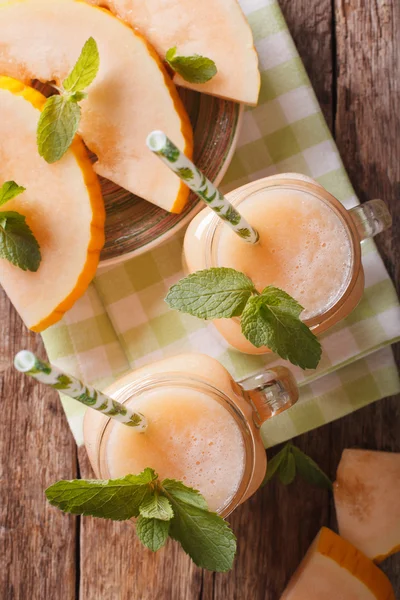 Melon juice in the glass on the wooden table. Vertical top view — Stock Photo, Image