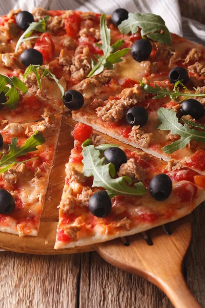 Pizza z tuńczykiem, oliwkami i rukolą zbliżenie w plasterkach. pionowe — Zdjęcie stockowe
