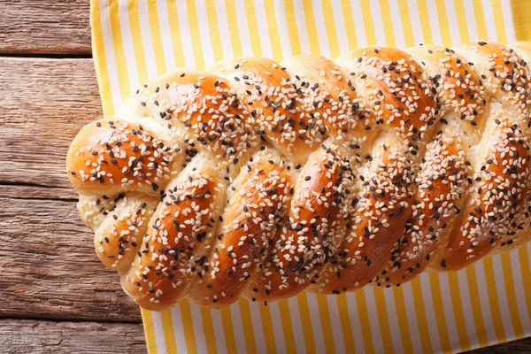 Pão trançado saboroso com sementes de sésamo fechadas na mesa. horizonte — Fotografia de Stock