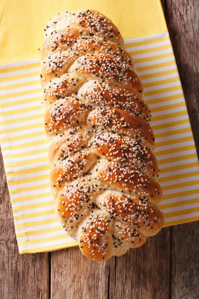 Pão recém-assado de trançado, com sementes de gergelim de perto. Verti. — Fotografia de Stock