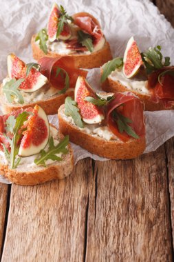 Bruschetta olgun incir, jambon, roka ve peynir ile kapatmak-