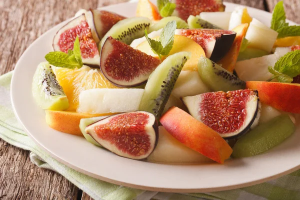 Delicious sliced fruit fig, peach, melon, kiwi and orange close- — Stock Photo, Image