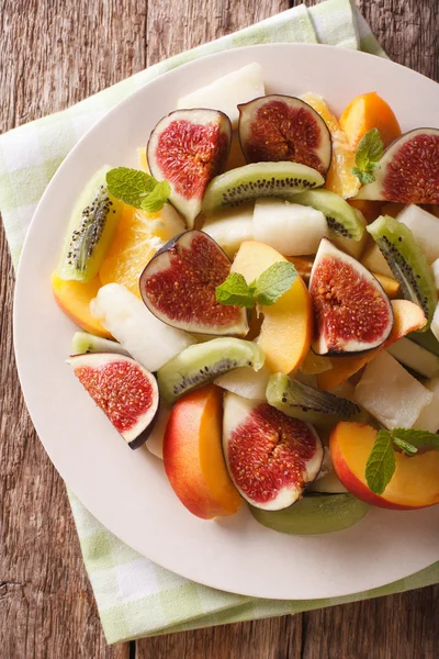 Sliced fresh fruit: figs, peaches, melons, kiwi and orange close — Stock Photo, Image