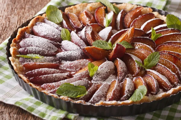 Delicious pastry: plum tart with mint and powdered sugar close-u — Stock Photo, Image