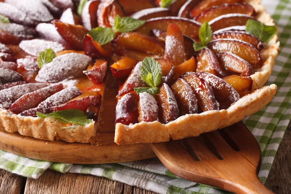 Sliced plum tart close-up on the table. horizontal — Stock Photo, Image