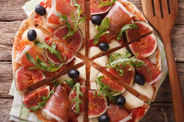 İncir, jambon, peynir ve arugula yakın çekim ile dilimlenmiş pizza. horizo