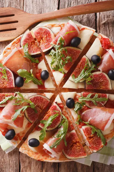 Sliced pizza with figs, ham, cheese and arugula close-up. vertic — Stock Photo, Image