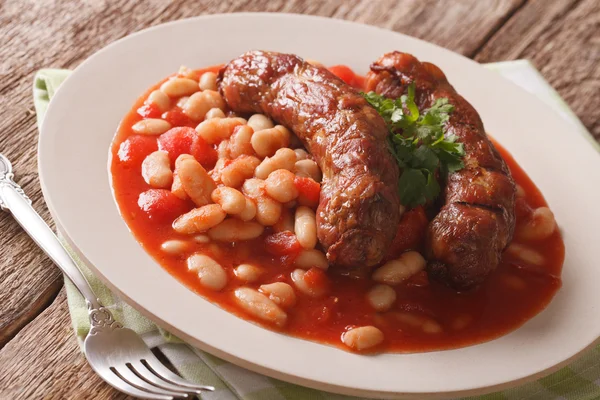 Grilled sausage with beans in tomato sauce on a plate close-up. — Stock Photo, Image