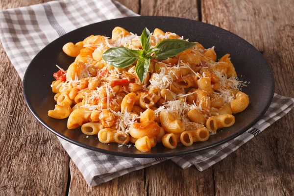 gomiti pasta with tomatoes, beans and parmesan on a plate close-