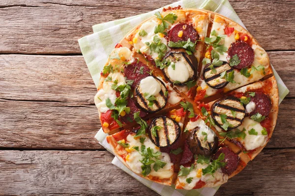 Pizza con melanzane, salumi e mozzarella da vicino su una tavola . — Foto Stock