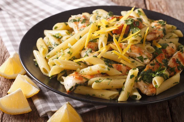 Penne pasta met pesto, gegrilde kip en citroen close-up. HORIZ — Stockfoto