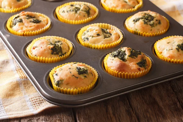 Muffins met verse spinazie en fetakaas close-up in baksel di — Stockfoto