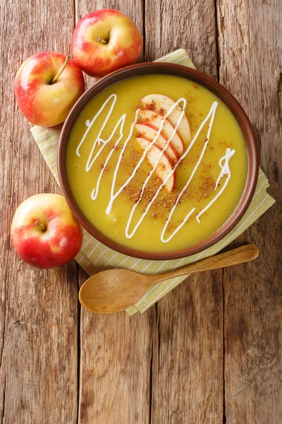 Apple curry soup puree with cinnamon close-up in a plate on the table. vertical top view from abov