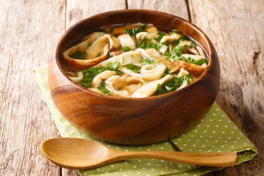Homemade pancake soup with parsley in a rich broth close-up in a bowl on the table. horizonta