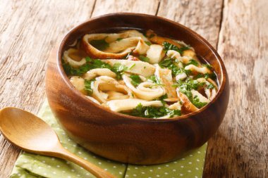 Beef Broth with Fritatten Austrian soup recipe close-up in a plate on the table. horizonta