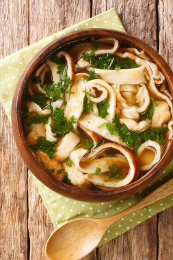 Frittatensuppe sliced pancake soup close-up in a plate on the table. vertical top view from abov