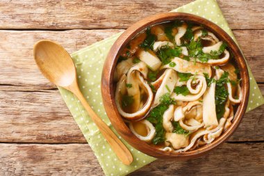 Soup with sliced crepes with bulonomkrupnym up to the plate on the table. horizontal top view from abov