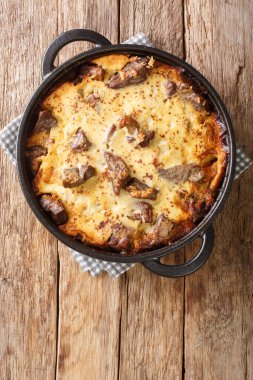 Albanian lamb and rice Tave kosi casserole baked with a mixture of yoghurt and eggs close-up in a pan on the table. vertical top view from abov