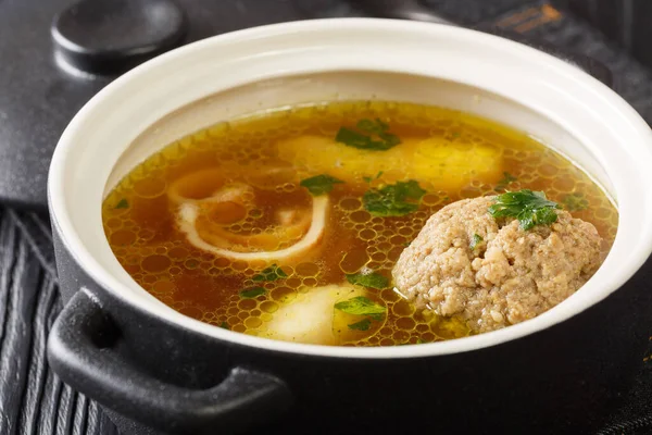 Beef broth or Rindsuppe is the most popular of Austrias with pancake strips Frittaten, semolina dumplings, liver dumpling close-up in a saucepan on the table. horizontal — Stock Image Beef Broth Rindsuppe Most Popular Austrias Pancake Strips Frittaten Semolina Royalty Free Stock Images