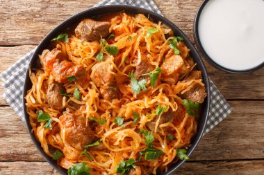 Domuz eti ve kırmızı biberli lahana yahnisi masanın üstünde. Yukarıdan yatay üst görünüm