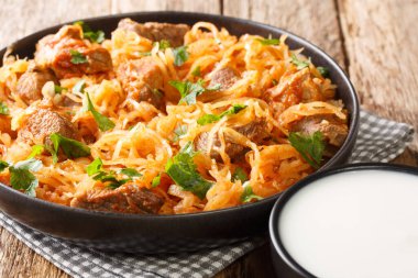 Domuz eti ve kırmızı biberli lahana yahnisi masanın üstünde. yatay