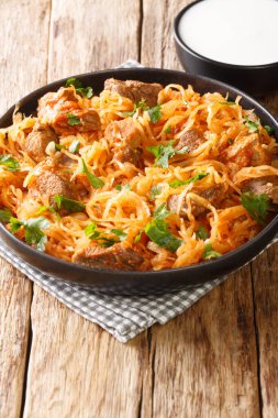 Masadaki kırmızı biber çorbasının içinde domuz eti, soğan ve lahana turşusu ile Szegedin gulaş. Dikey