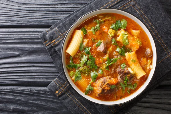 スープジュムーやハイチの牛肉やカボチャのスープは 牛肉や野菜と一緒に調理された有名な弱スパイシーなスープで テーブルの上にプレート内のリガトーニパスタを閉じます Abovからの水平方向のトップビュー — ストック写真