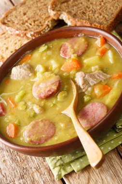 Sebzeli Hollanda Bezelye Çorbası Erwtensoep, sosis ve domuz eti masadaki tabağa yakın. dikey