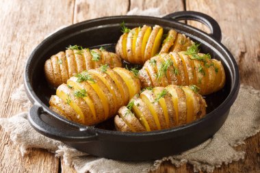 Klasik Hasselback patatesi tarifi. Masadaki tavaya yakın plan. Yatay