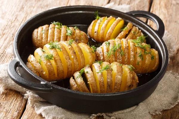 Kırsal tarzda dilimlenmiş ve pişmiş Hasselback patatesleri masanın üstünde yakın plan. Yatay