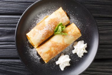 Palatschinken Austrian Sweet Pancakes with apricot jam close-up in a plate on the table. horizontal top view from abov