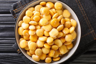 Masanın üzerindeki bir kasede tuzlanmış sarı lupin fasulyesi. Yukarıdan yatay üst görünüm