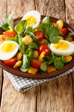 Lupin fasulyeli diyet salatası, haşlanmış yumurta, domates ve masada yakın plan fındık salatası. dikey