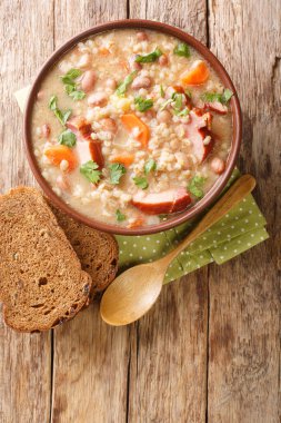 Füme et ve sebzeli arpa ve fasulye çorbası masanın üstünde yakın plan. yukarıdan dikey üst görünüm