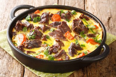 Karadağ yemeği Balsica tava dana eti yumurta, ekşi krema ve sütle pişirilmiş sebzeler masanın üstünde yakın plan. yatay