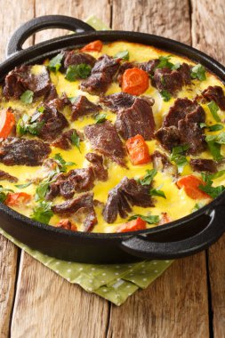 Karadağ mutfağı kaynatıldı ve yumurta sütü soslu sığır eti masada yakın plan bir tavada pişirildi. dikey