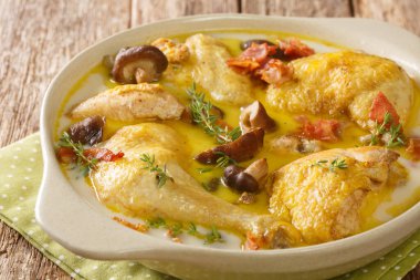 Fransız yemeği Coq au vin Riesling tavuğu kremalı, pastırmalı ve mantarlı beyaz şarap masanın üstünde. yatay