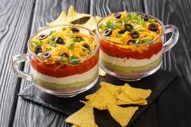 Meksika yemeği otantik yedi katlı fasulye ezmesi salatası, guacamole, ekşi krema ve salsa sosu masaya yakın plan. yatay