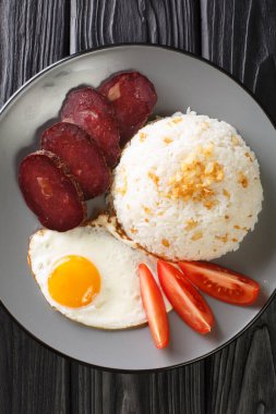 Garlic rice served with fried egg and jerky close-up in a plate on the table. vertical top view from abov
