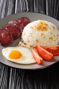 Garlic rice served with fried egg and jerky close-up in a plate on the table. vertica