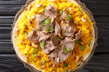 Mansaf, bir tabak pilav, kuzu eti ve masadaki tabakta Jameed yakın çekim adı verilen bir sosa dönüştürülmüş kuru yoğurt. Yukarıdan yatay üst görünüm