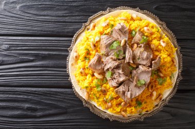 Jordan Mansaf 'ın ulusal favorisi geleneksel Bedevi mutfağı. Masanın üzerindeki tabakta güzel bir ortak yemek oluşturur. Yukarıdan yatay üst görünüm