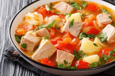 Masadaki tabakta ton balığı, patates, domates ve biberden yapılmış klasik Bask menüsü için Marmitako tarifi. Yatay